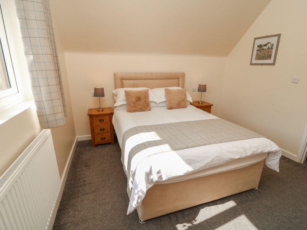 A bedroom with a bed and nightstand at James Ville Marina Lodge 10 in Brigg
