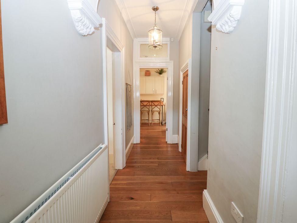 A hallway with a light fixture and wooden flooring at Hampton House in St. Bees