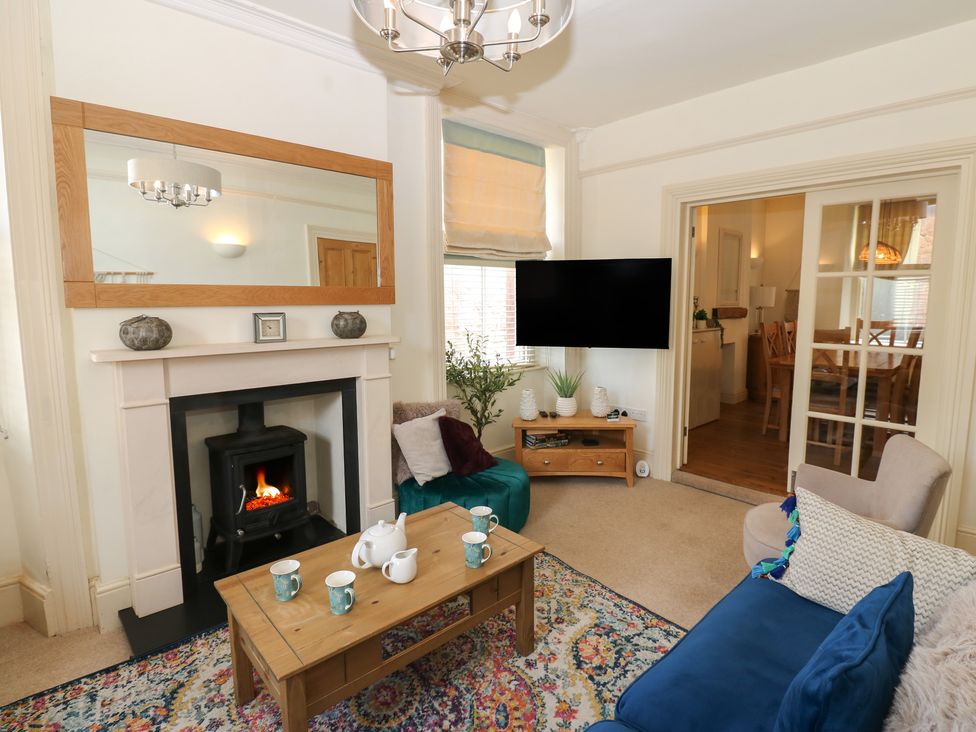 A living room with a fireplace and television at Hampton House in St. Bees