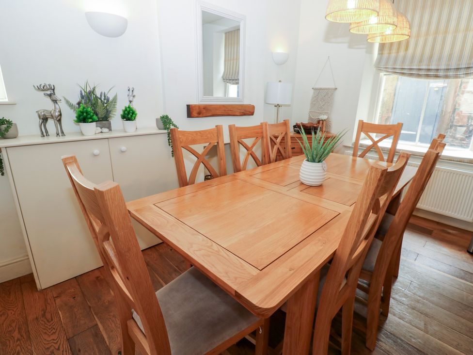 A dining room with a wooden table and chairs at Hampton House in St. Bees