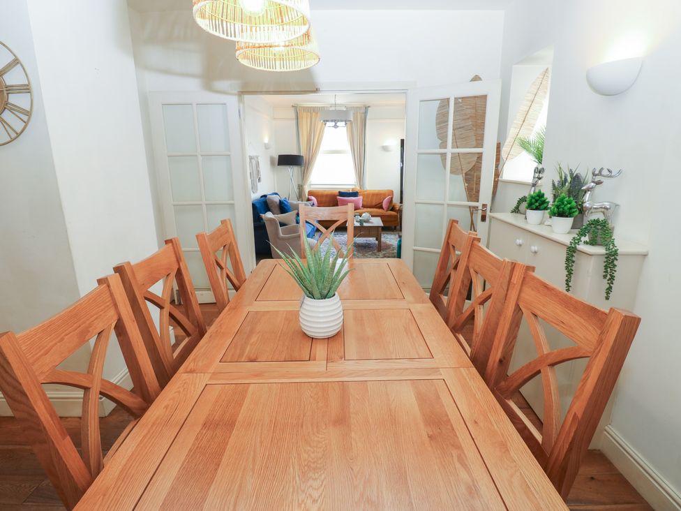 A dining room with a wooden table and chairs at Hampton House St. Bees