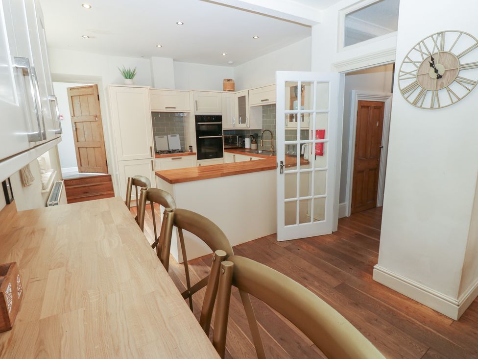 A kitchen with an island and stools at Hampton House in St. Bees