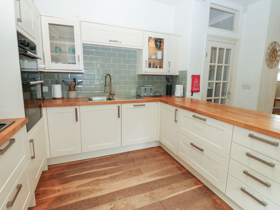 A kitchen with cabinets and a sink at Hampton House in St. Bees