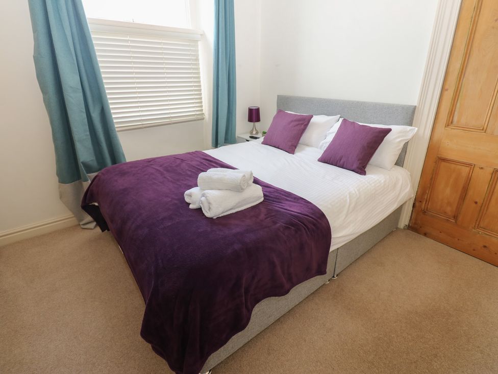 A bedroom with a bed and lamps at Hampton House in St. Bees