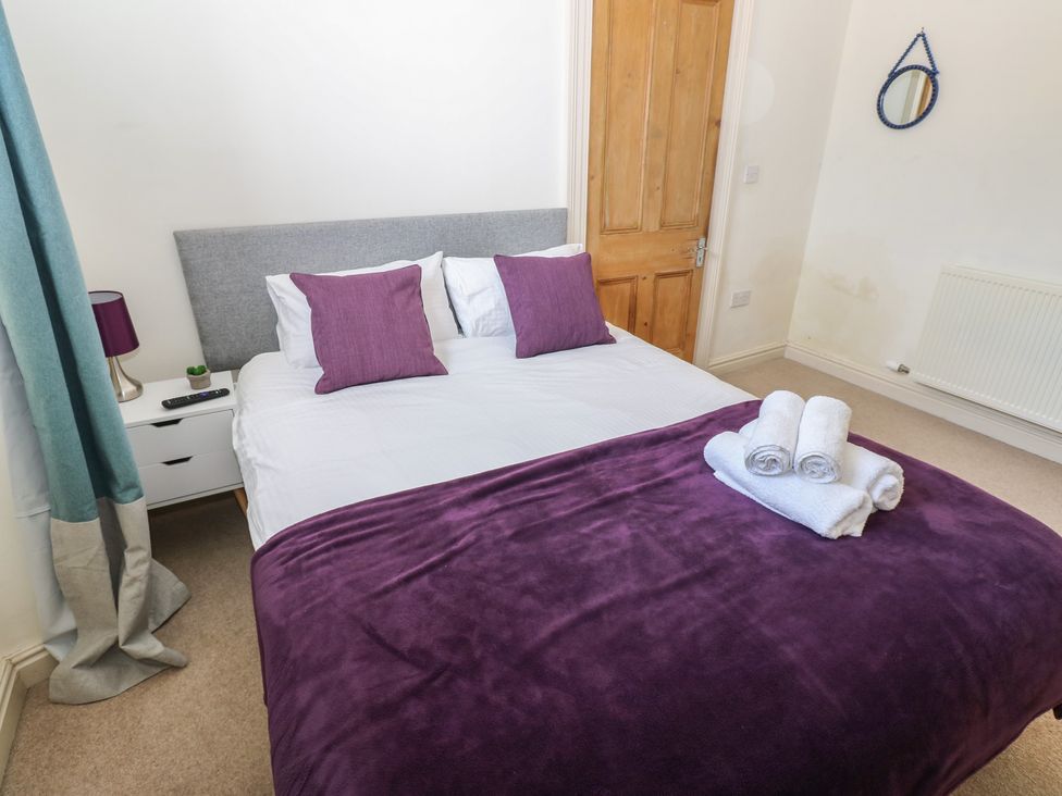 A bedroom with a double bed and towels at Hampton House in St. Bees
