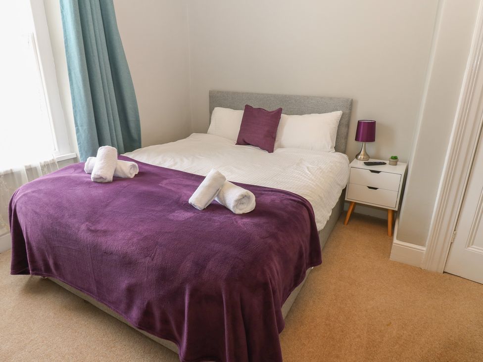 A bedroom with a bed and nightstand at Hampton House in St. Bees