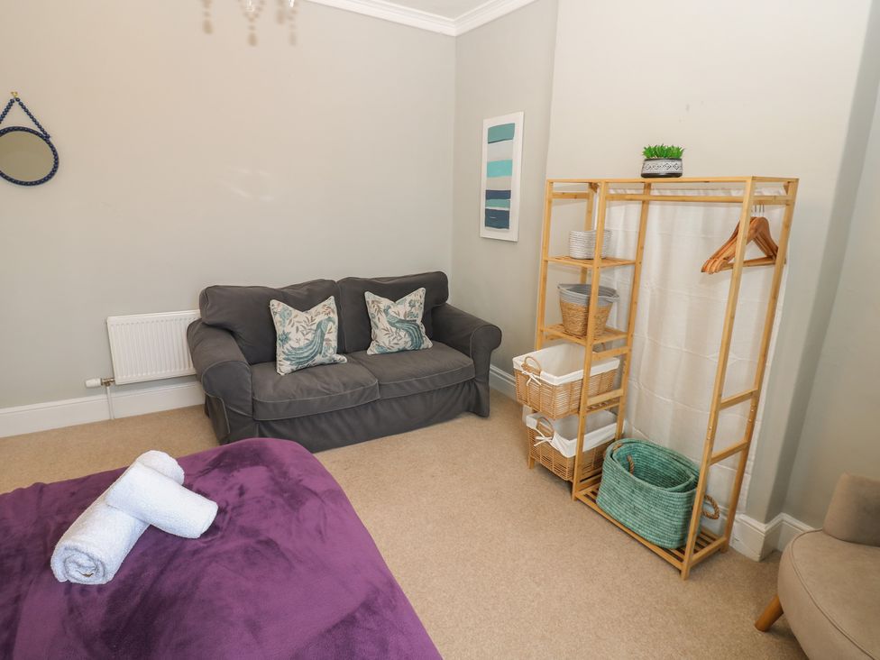 A living room with a sofa and decorative shelves at Hampton House in St. Bees