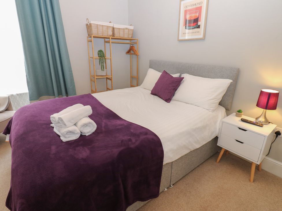 A bedroom with a bed and a bedside table at Hampton House in St. Bees