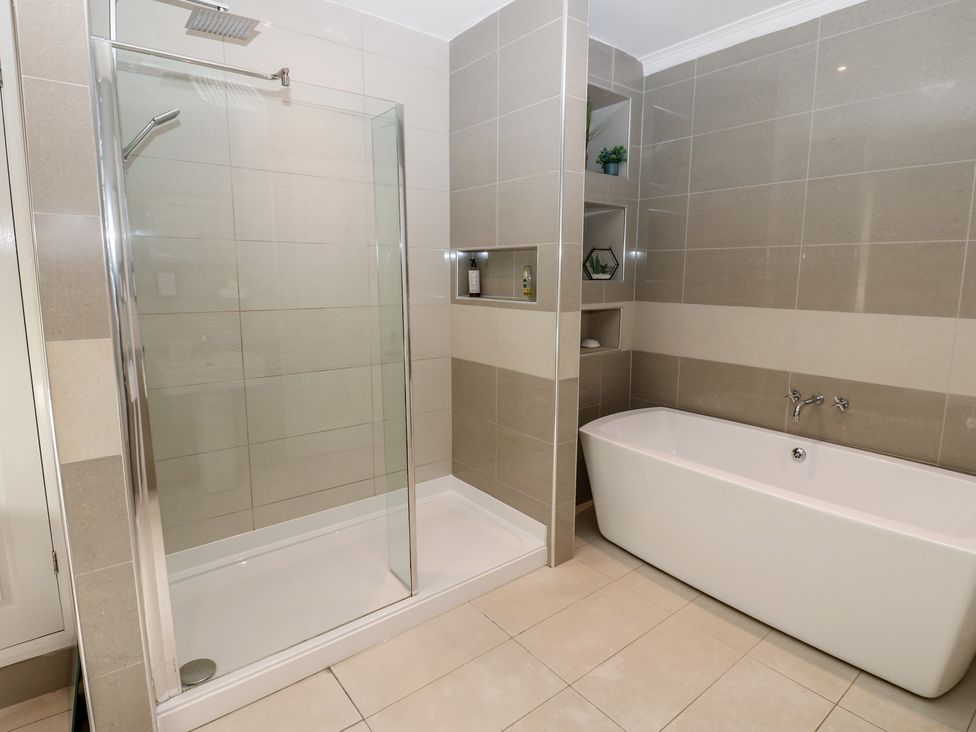 A bathroom featuring a shower and a bathtub at Hampton House in St. Bees
