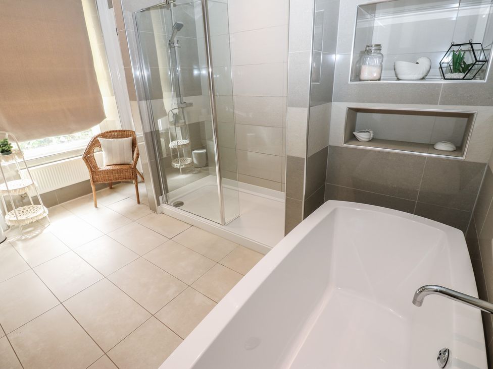 A bathroom with a bathtub and shower at Hampton House in St. Bees