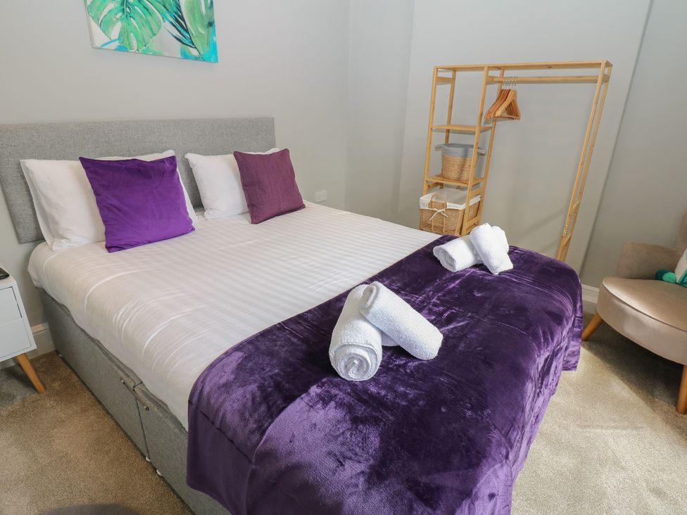 A bedroom with a bed and towels at Hampton House in St. Bees