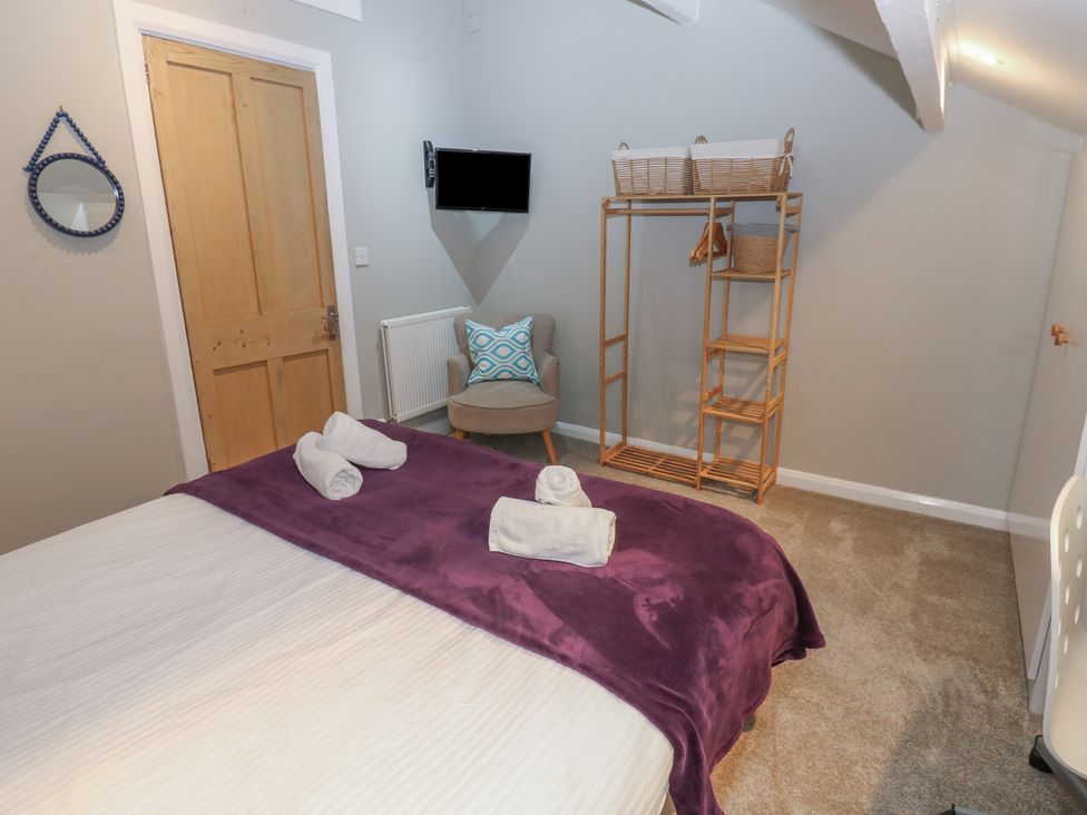 A bedroom with a bed and a chair at Hampton House in St. Bees