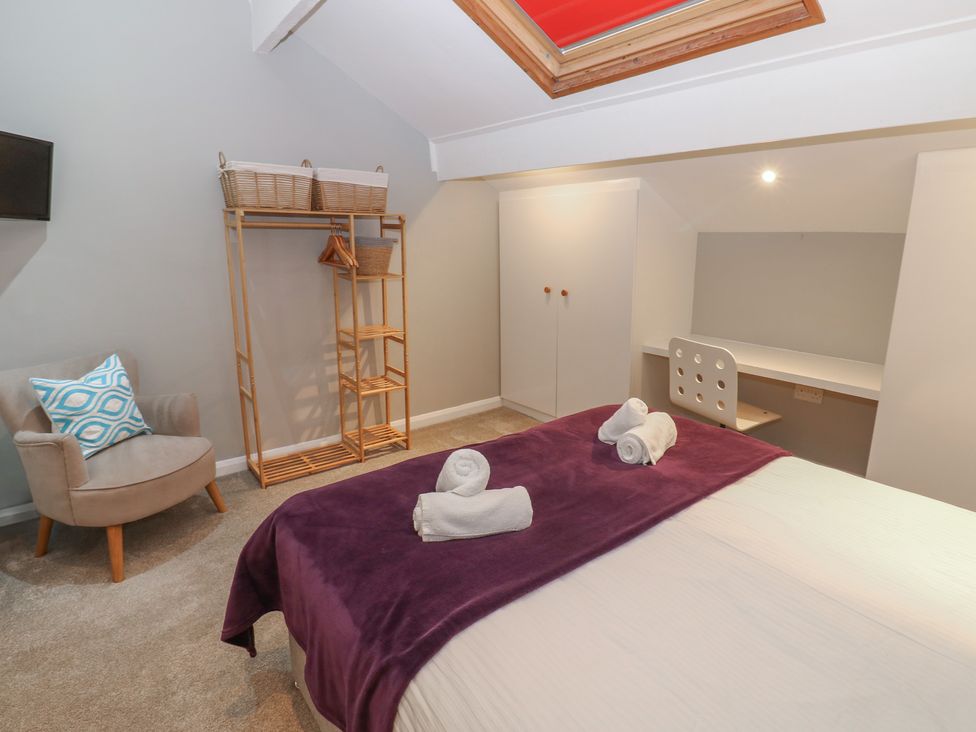 A bedroom with a bed and desk at Hampton House St. Bees