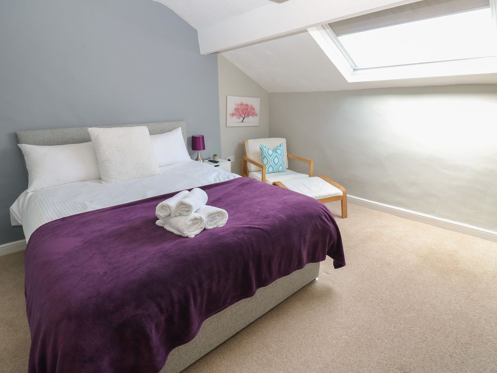 A bedroom with a bed and armchair at Hampton House in St. Bees