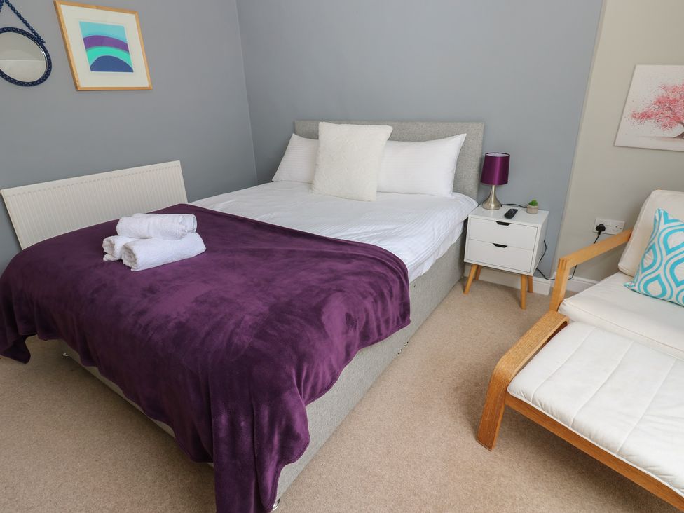 A bedroom with a bed and side table at Hampton House in St. Bees