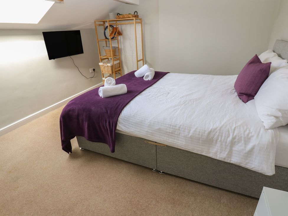 A bedroom with a bed and a television at Hampton House in St. Bees