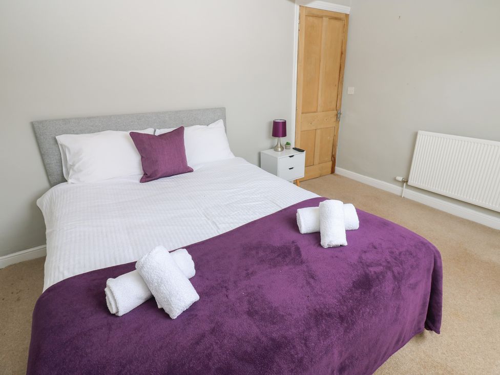 A bedroom with a bed and towels arranged at Hampton House St. Bees