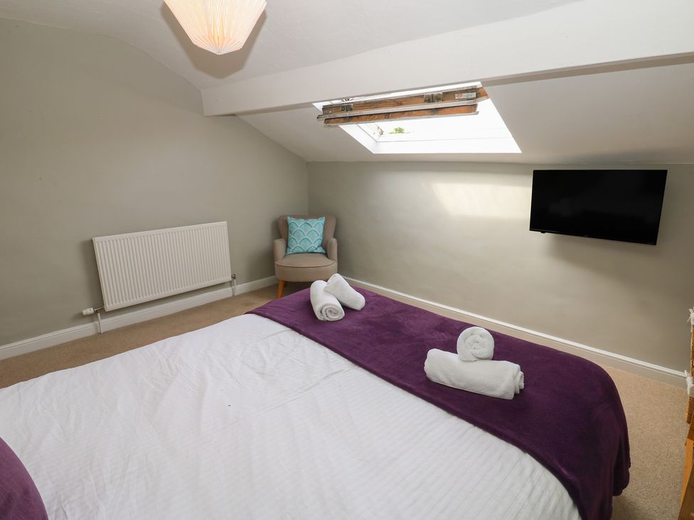 A bedroom with a bed and towels at Hampton House in St. Bees