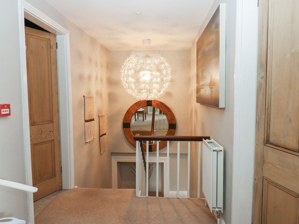 A hallway with a mirror and light fixture at Hampton House, St. Bees