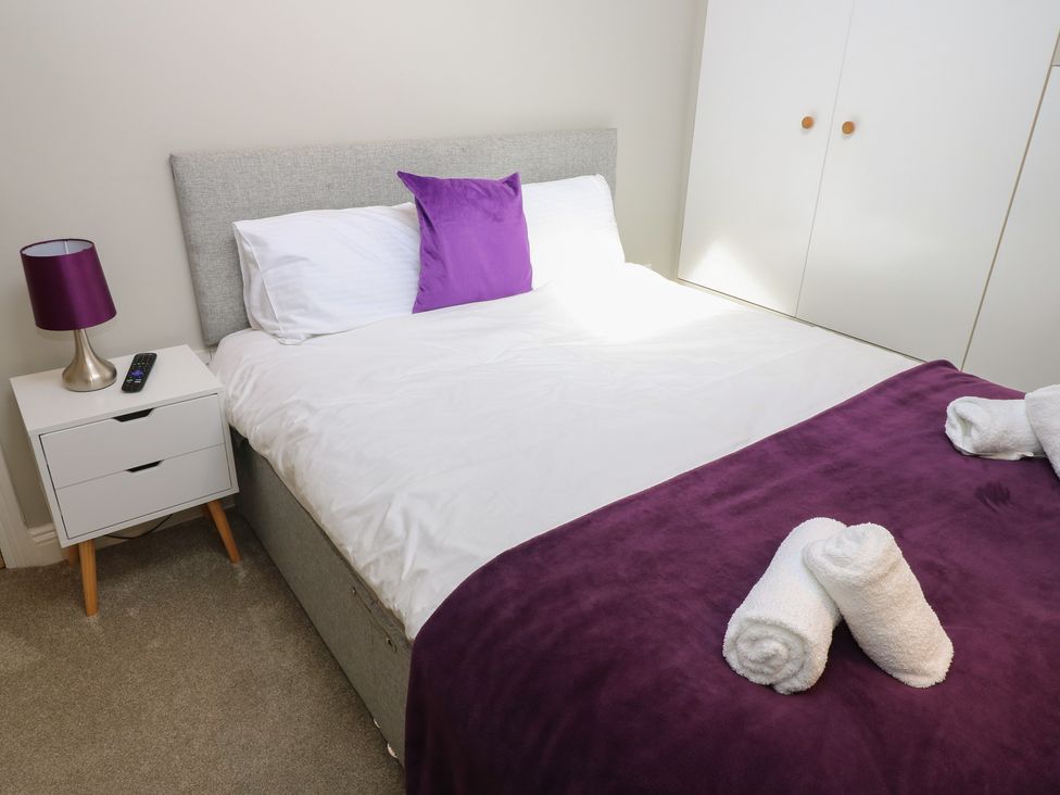 A bedroom with a bed and bedside table at Hampton House in St. Bees