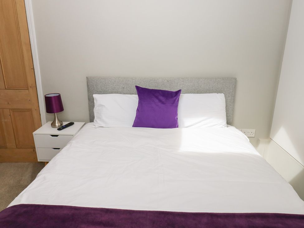 A bedroom with a bed and bedside table at Hampton House in St. Bees