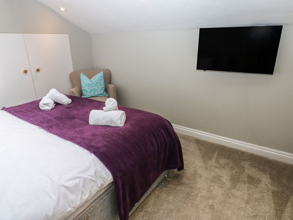A bedroom with a bed and television at Hampton House in St. Bees