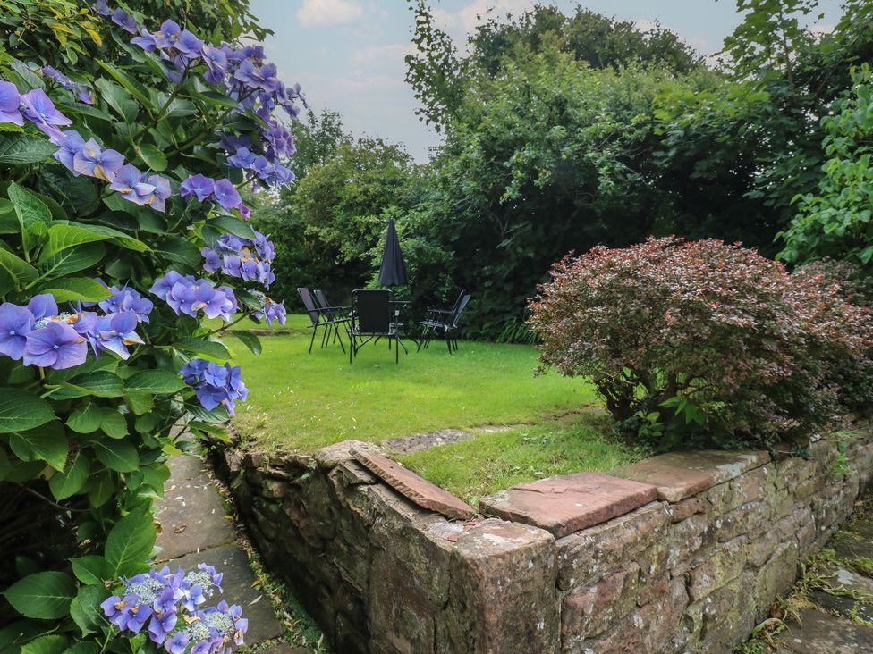 A garden with flowers and seating area at Hampton House in St. Bees