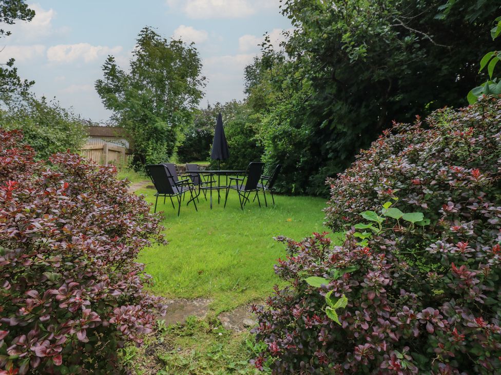 A garden with a table and chairs at Hampton House in St. Bees