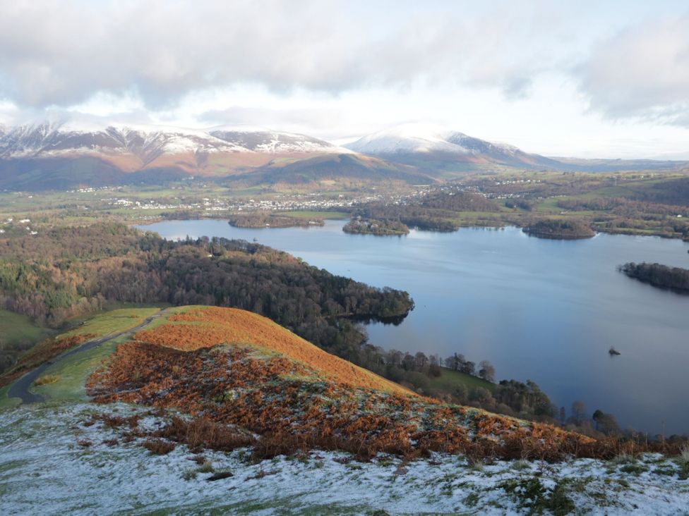 A view of mountains and a lake with trees in the foreground at Hampton House in St. Bees
