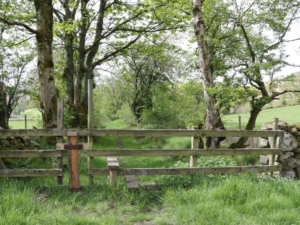 A wooden gate with a path leading into a grassy area at Hampton House in St. Bees