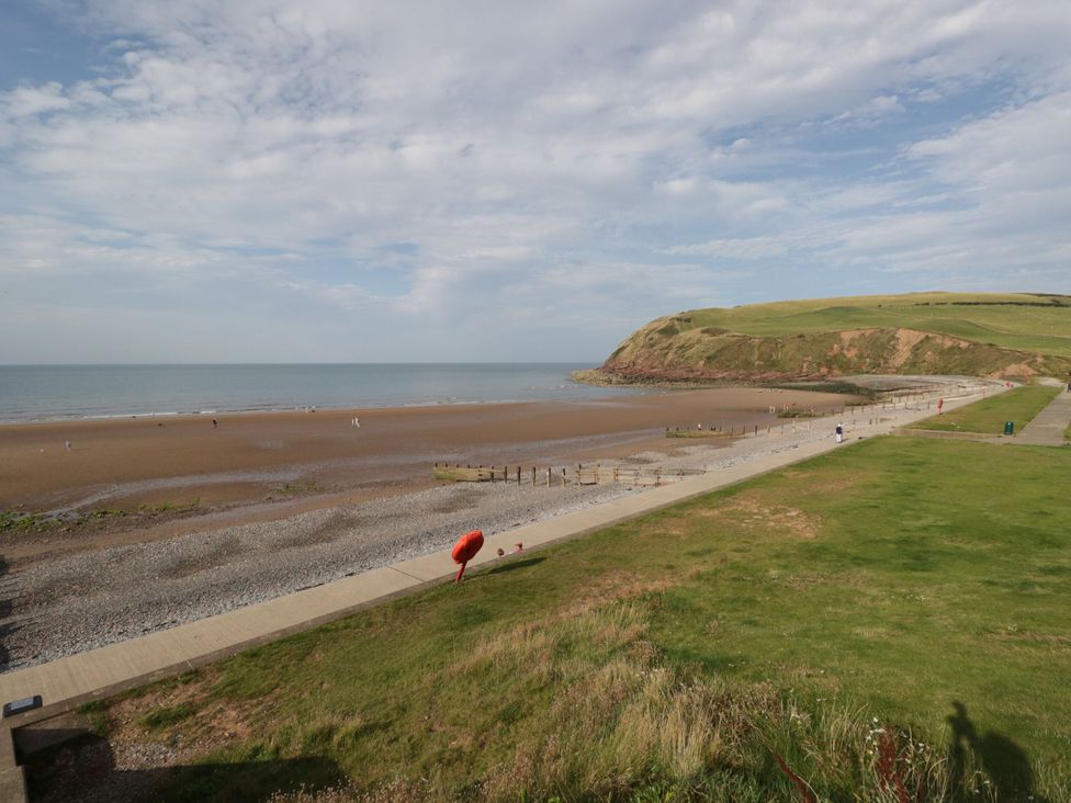 A beach with a pathway and grass area at Hampton House in St. Bees