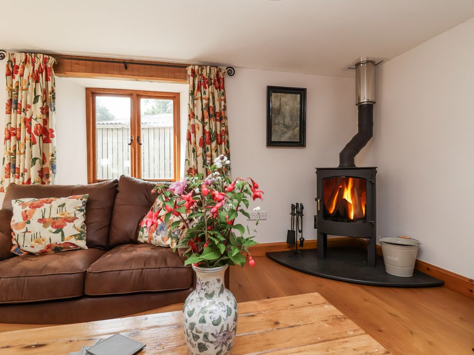A living room with a fireplace and curtains at Lane End in North Molton