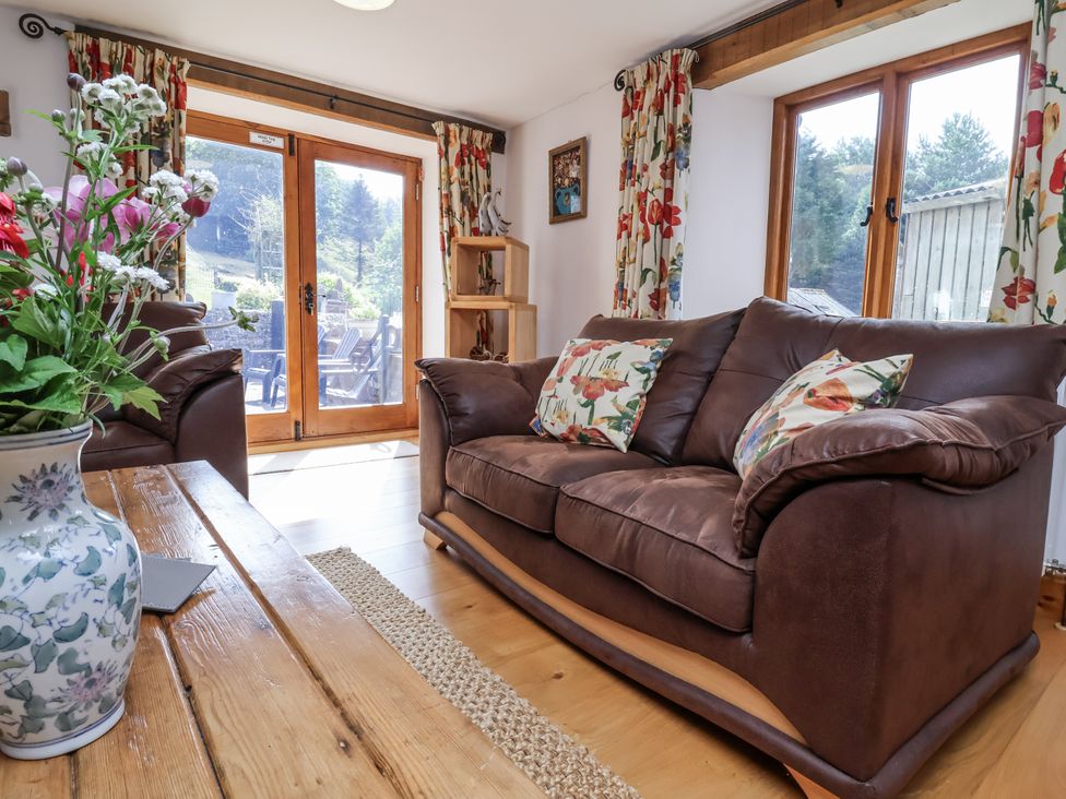 A living room with a sofa and table at Lane End in North Molton