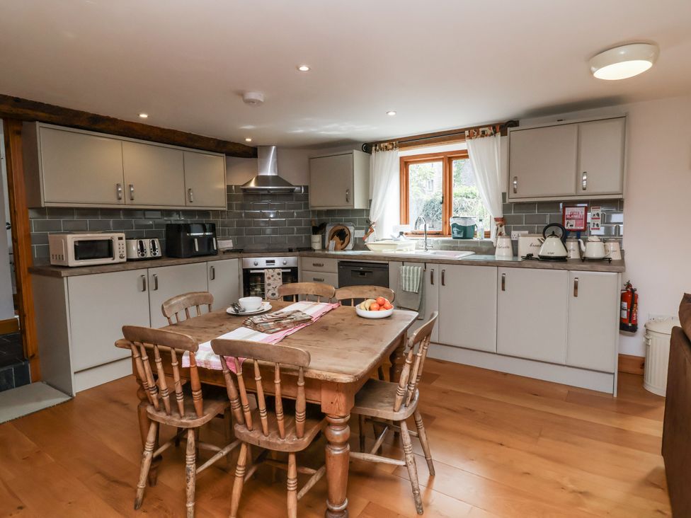 A kitchen with a dining table and appliances at Lane End in North Molton