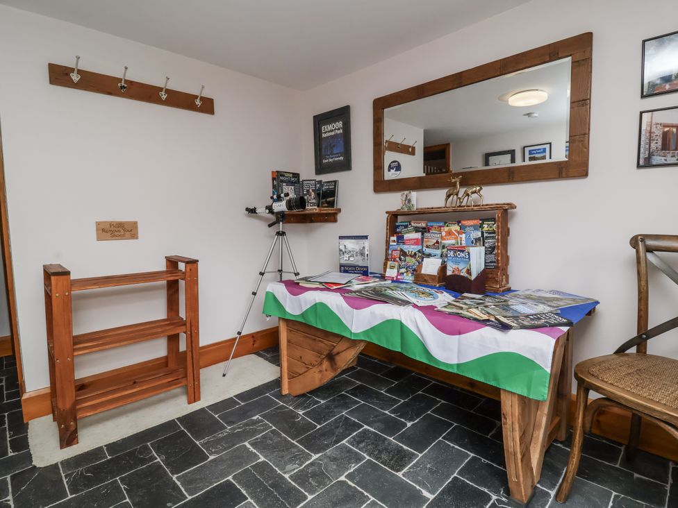 A lobby with a table displaying brochures and a mirror at Lane End in North Molton