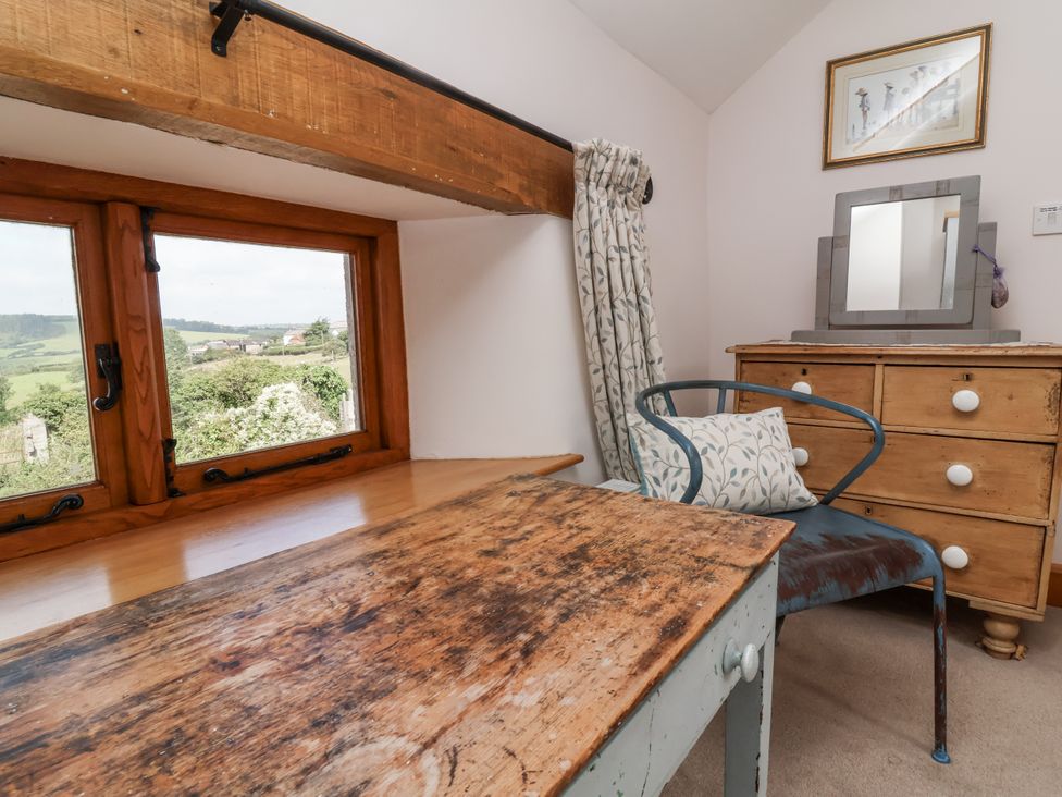 A bedroom with a window and a dressing table at Lane End in North Molton