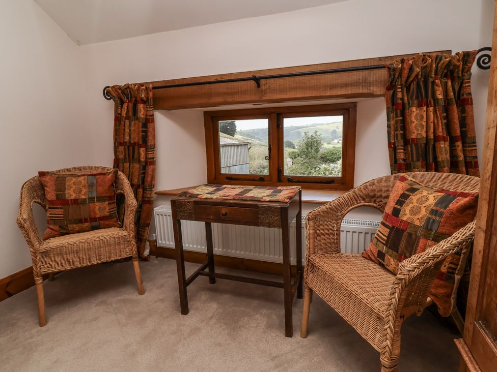 A sitting room with wicker chairs and a table at Lane End in North Molton