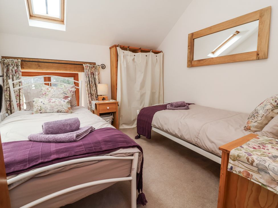 A bedroom with two beds and a window at Lane End in North Molton