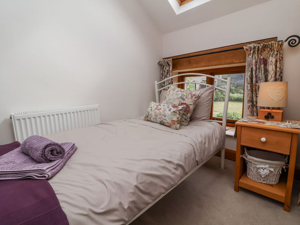 A bedroom with a bed and nightstand at Lane End North Molton