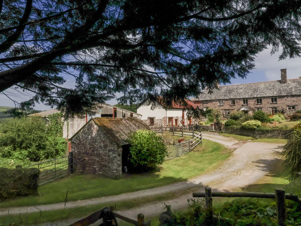 An outdoor view of a farm with buildings and trees at Lane End North Molton