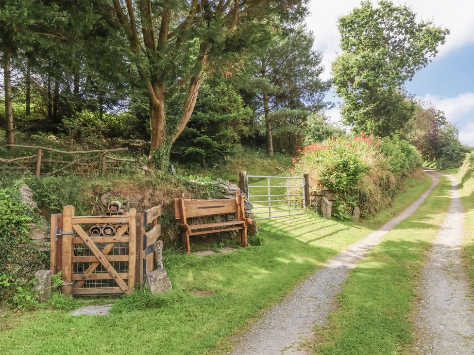 A gate and bench by a gravel path at Lane End North Molton