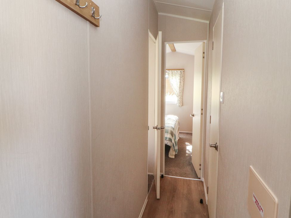 A hallway with doors to rooms and a window at Barnes Retreat in Carnforth