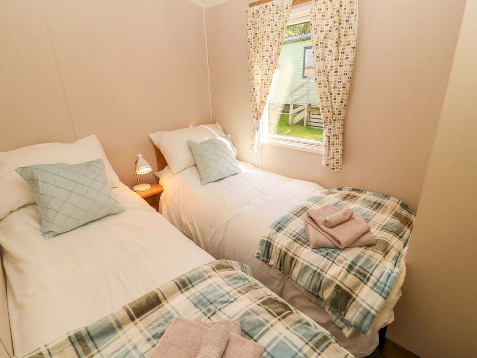 A bedroom with two beds and a window at Barneys Retreat in Carnforth