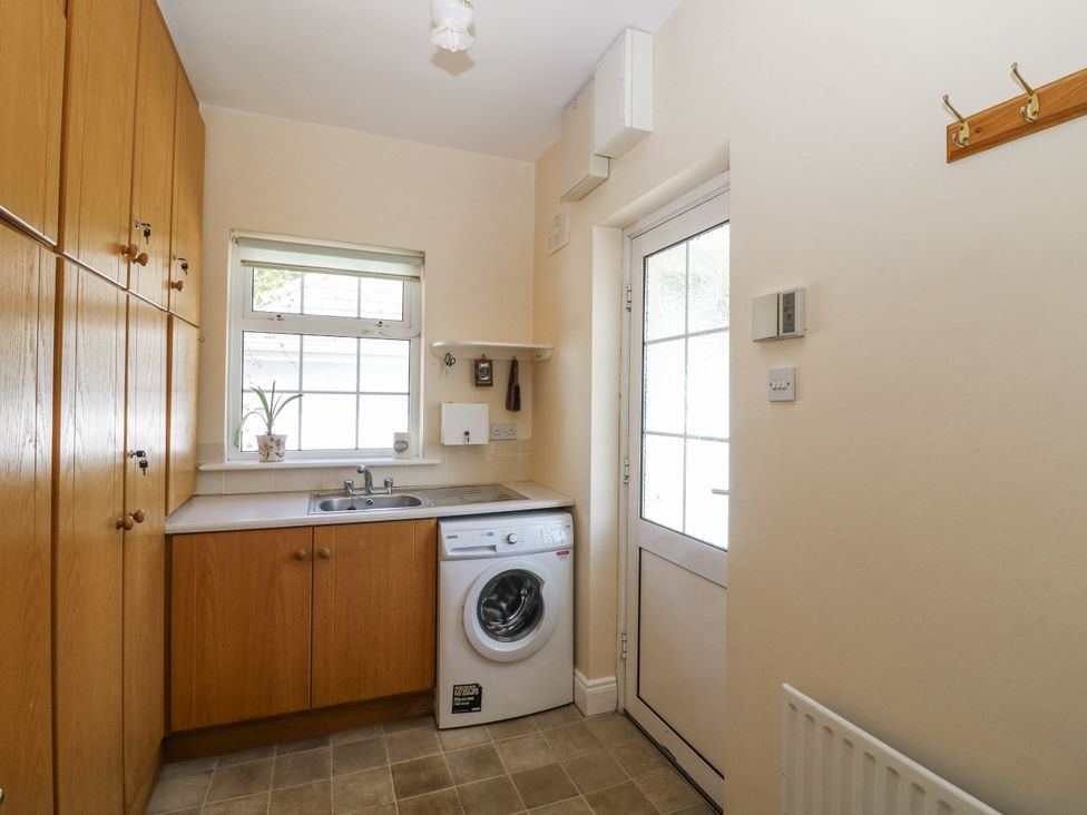 A laundry room with a washing machine and sink at Knockroe Lodge