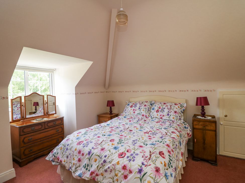 A bedroom with a bed and a mirror at Knockroe Lodge 