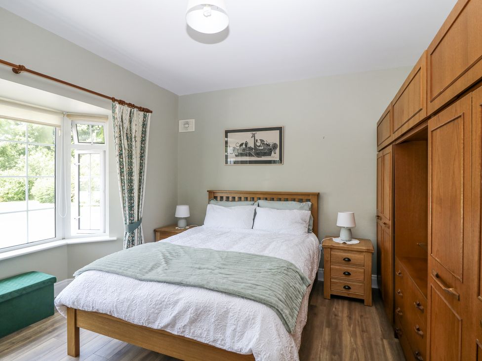 A bedroom with a bed and wardrobe at Knockroe Lodge