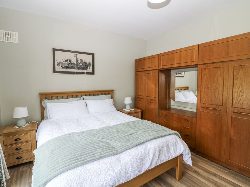 A bedroom with a bed and wardrobe at Knockroe Lodge