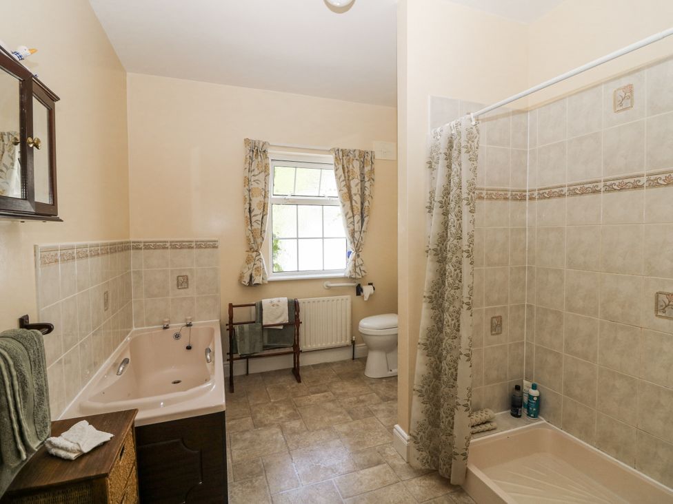 A bathroom with a bathtub, shower, and toilet at Knockroe Lodge