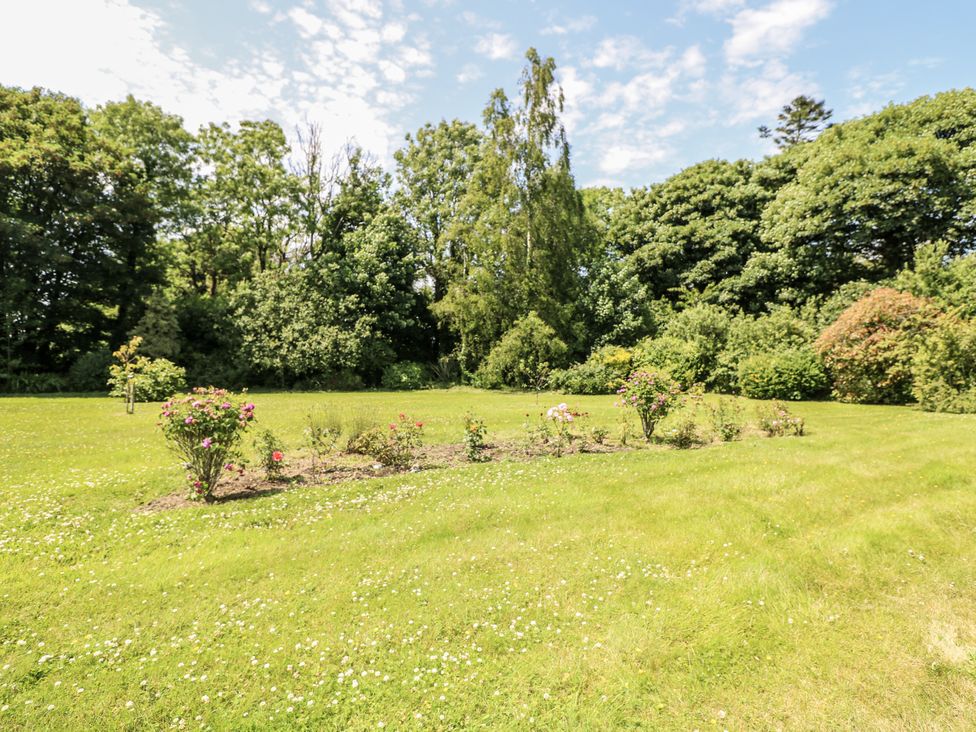 A garden with a flower bed and trees at Knockroe Lodge in 