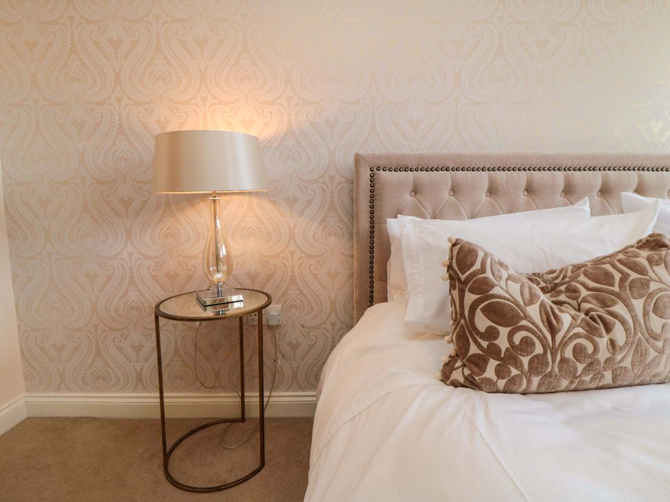 A bedroom with a bed and side table at Scalby Grove Cottage in Scalby